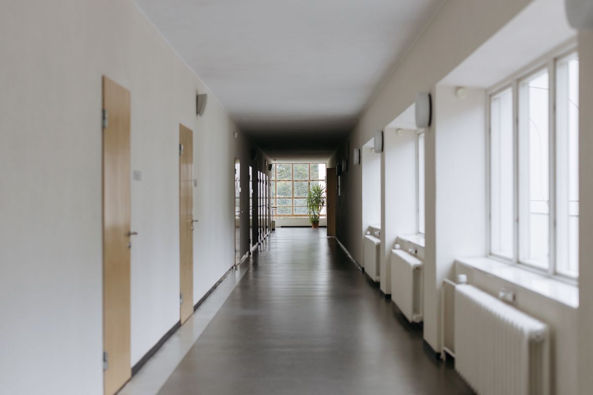 明るい学校の廊下に、木の教室ドアが2つ並んでいる。情緒級と知的級のどちらに入ることになるのかを考える場面のイメージ
