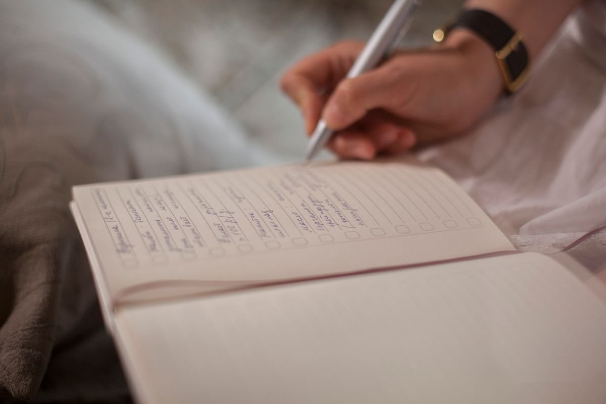 ノートを開き、ペンで箇条書きのメモを書き込んでいる手元。体験の申し込みの前に、家での様子や希望の時間帯を書き出しておくイメージ