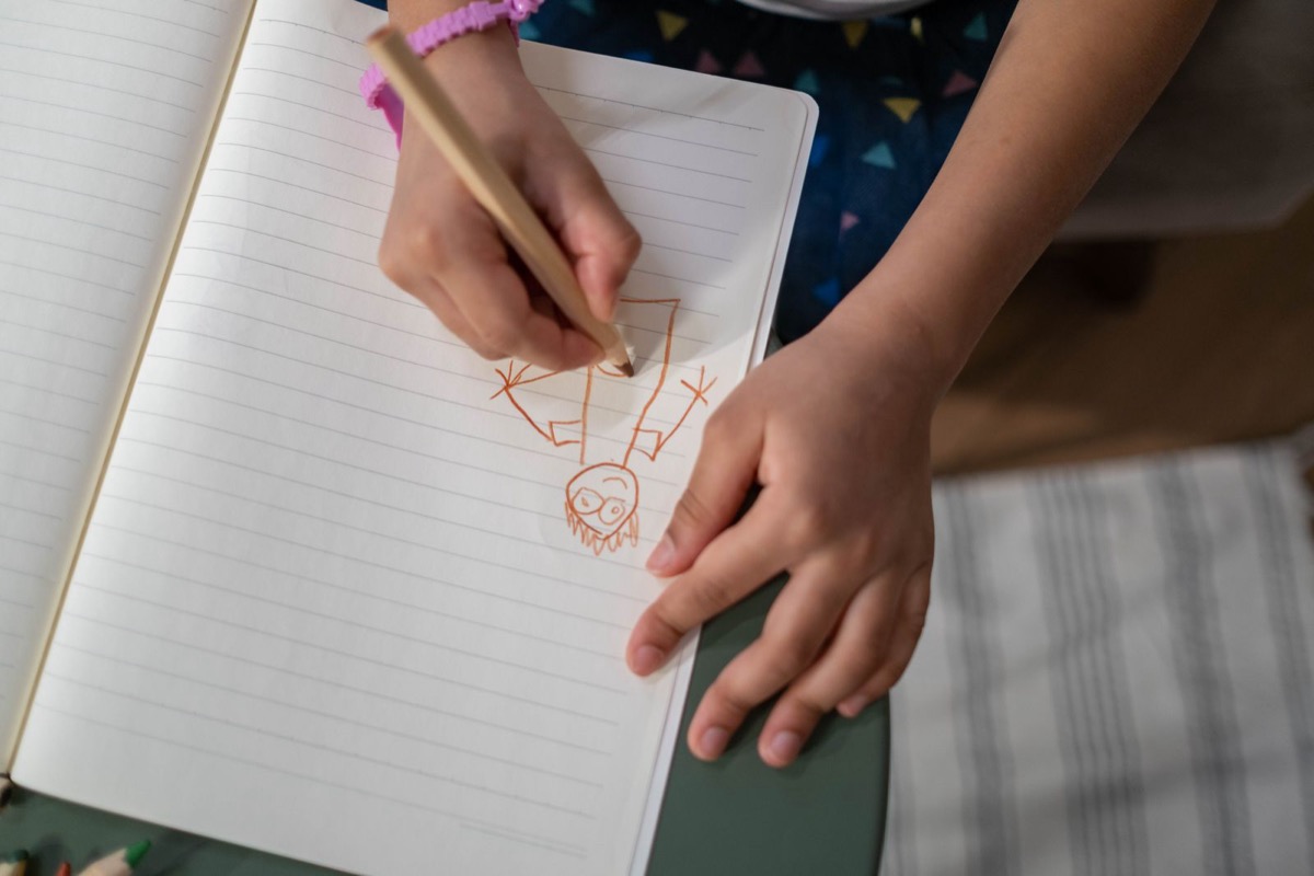 ノートに色鉛筆で絵を描く子どもの手元。声以外の伝え方を用意することが支えになる