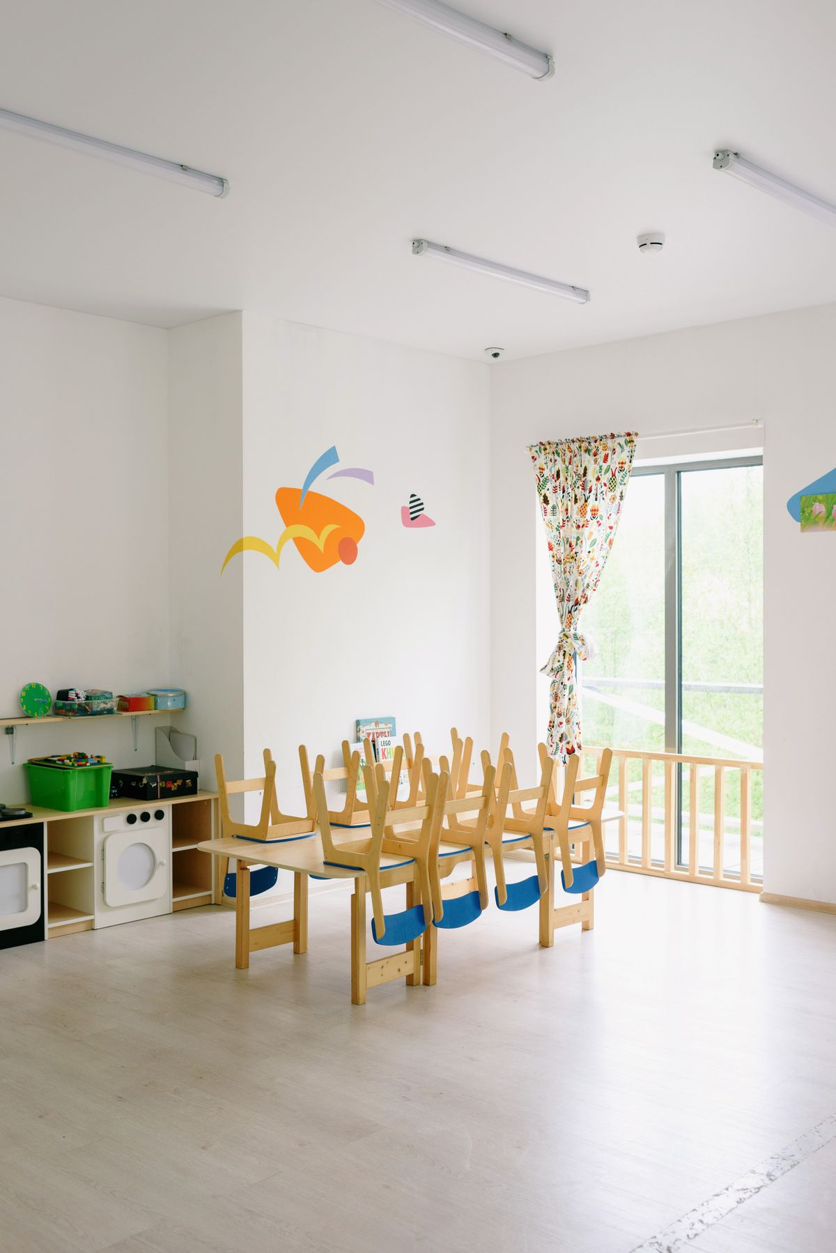 子ども用の木の机と椅子が並ぶ、明るく静かな活動室。人数や部屋の作りで集団活動の負担は大きく変わる