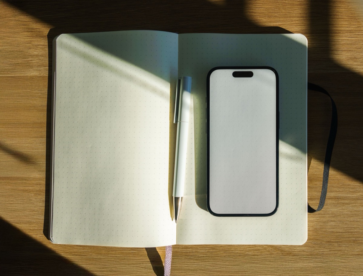 相談の電話をかける前に、聞きたいことを書き出すためのノートとペン、スマートフォンを机に並べたところ