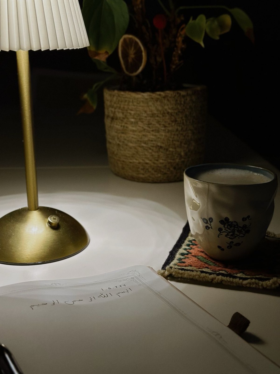 夜の机に灯る小さなスタンドライトと、開いたノートと飲みかけのカップ。子どもを寝かせたあと、診断を受けるかどうかを一人で考えている時間帯のイメージ